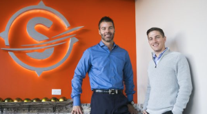 Stream Logistics Founders Carson Holmquist and Chad Patton in front of Company Sign